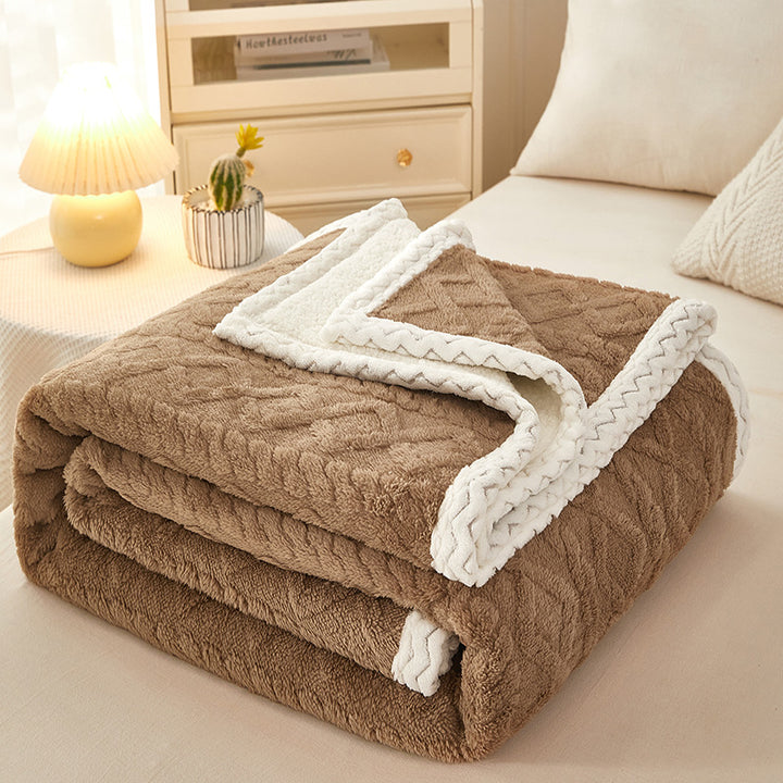 Thick sherpa fleece blanket folded on bed