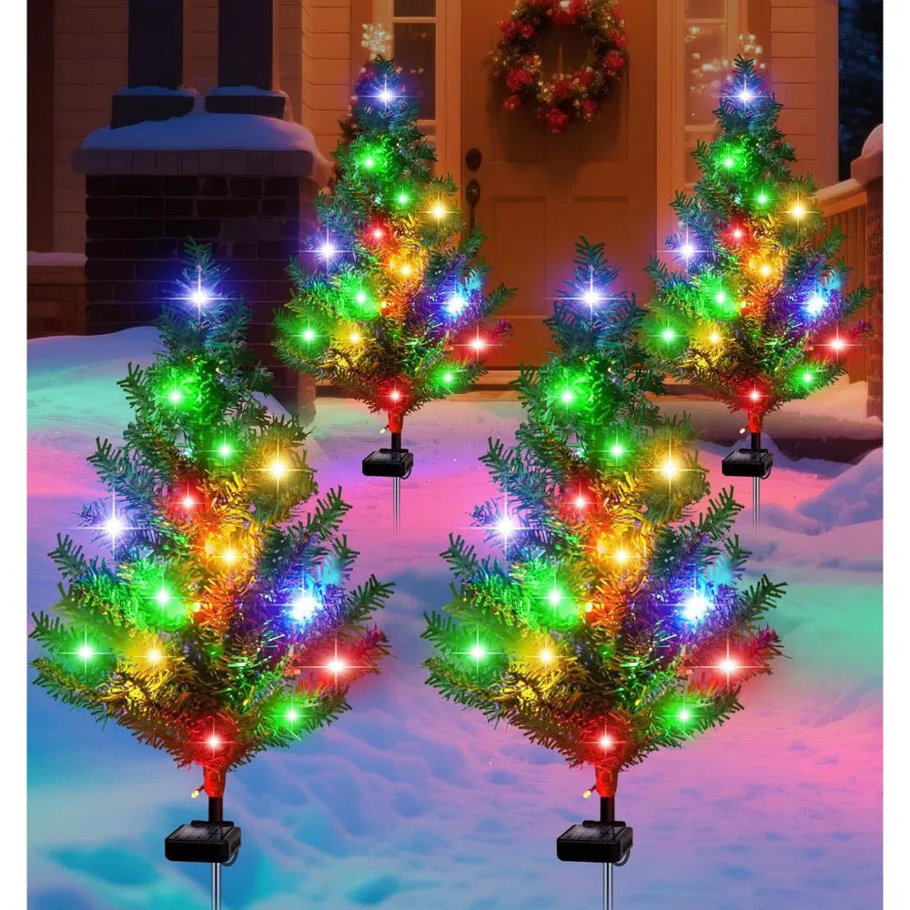 Four solar mini Christmas trees lit on lawn