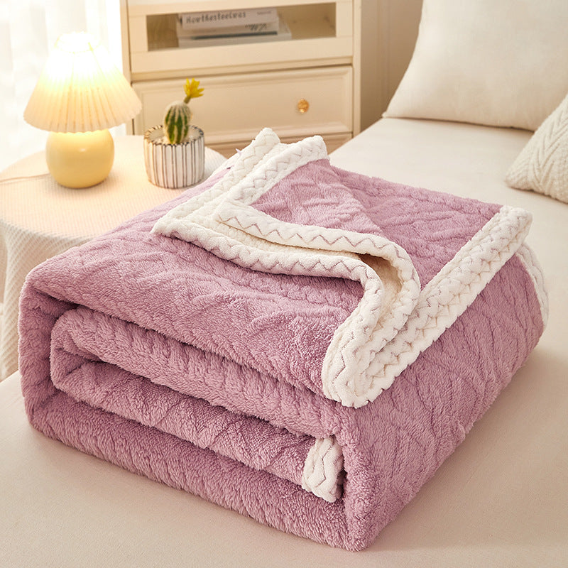 Thick sherpa fleece blanket folded on bed