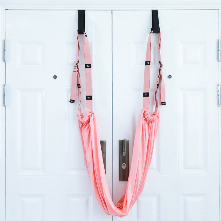 Yoga stretch strap hanging from a door
